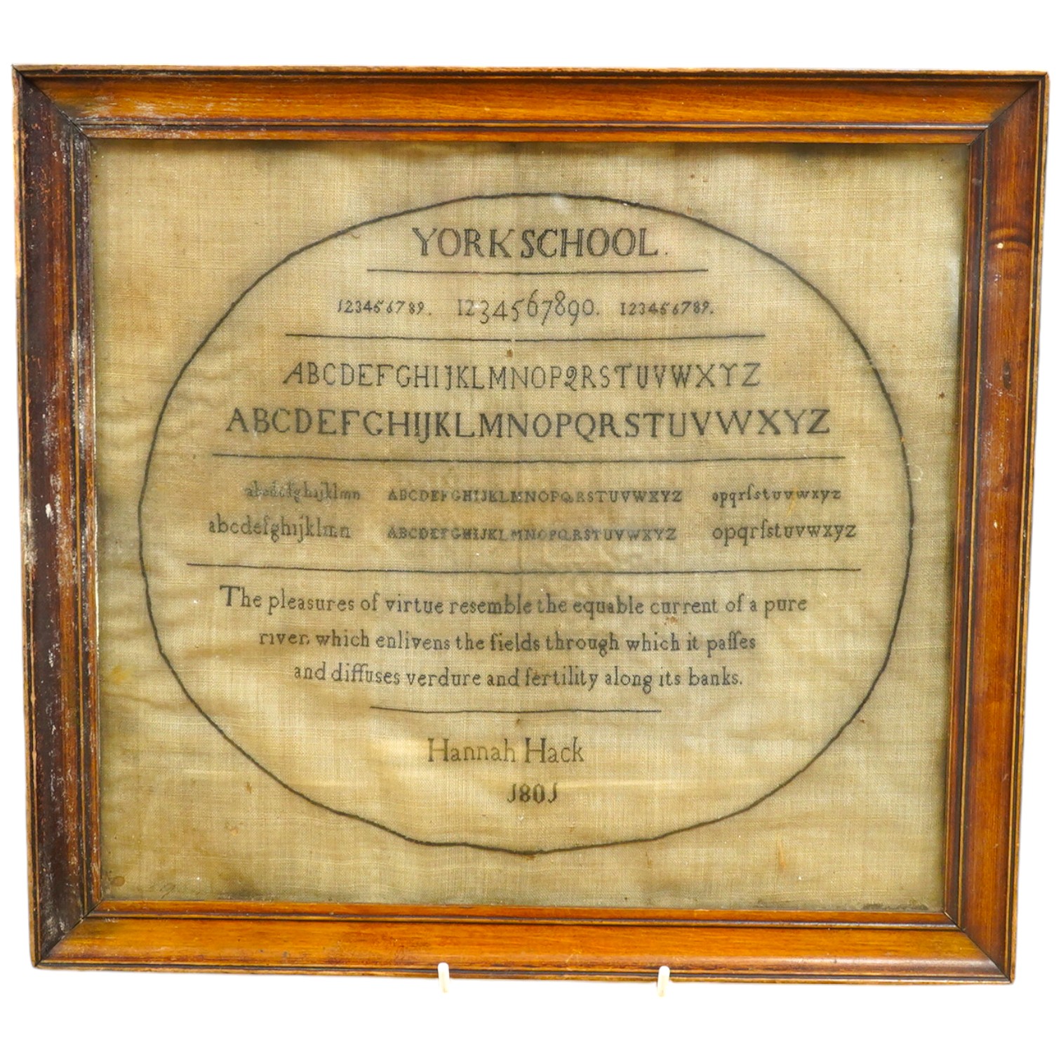 A Hannah Hack, York School, 1801 sampler, sewn within an embroidered black oval border, headed with York School above a row of numerals and two rows of lower case and capital letters, with a pastoral verse below then sig